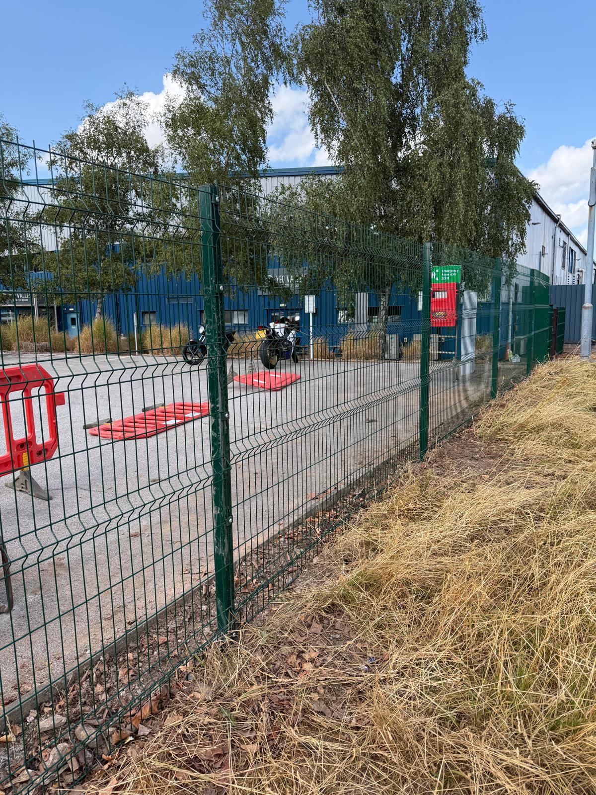 Green welded mesh perimeter fencing at an industrial estate